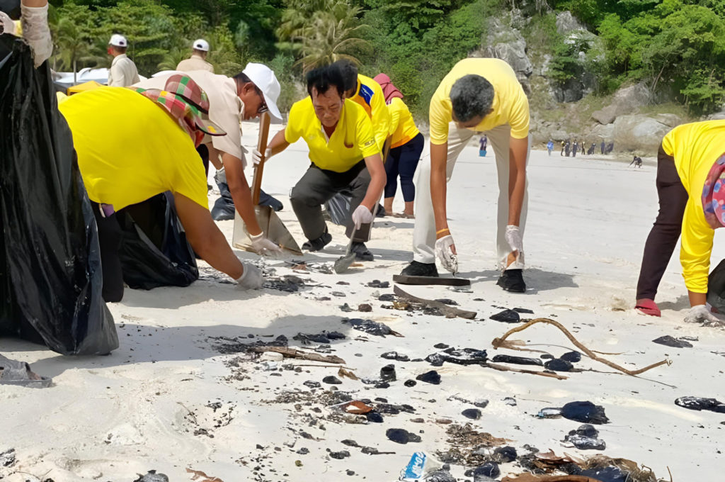 Волонтеры и сотрудники береговой охраны убирают остатки нефти с пляжа на острове Рача-Яй у побережья Пхукета (фото: офис муниципалитета Равай)