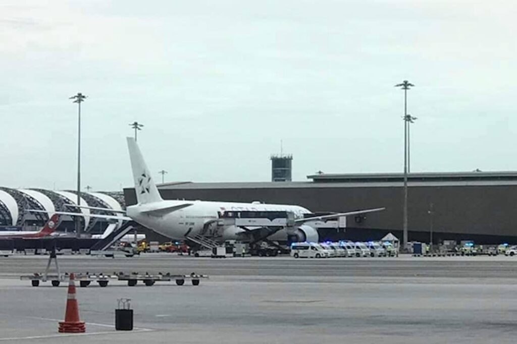 Машины скорой помощи и спасательные машины припаркованы рядом с самолетом Boeing 777-300ER авиакомпании «Сингапурские авиалинии» после аварийной посадки в аэропорту Суварнабхуми